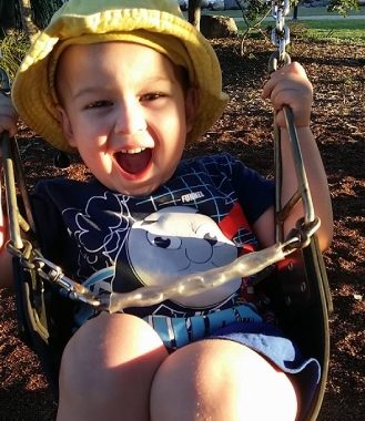 Beautiful boy on a swing in the park at Clontarf