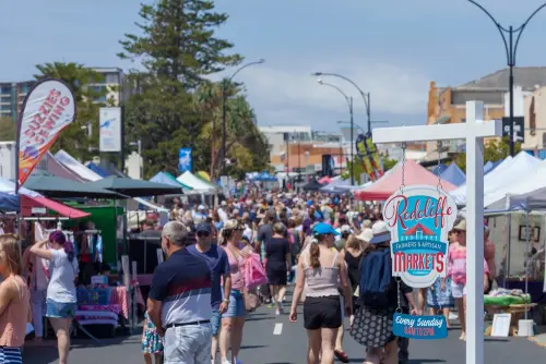 Visit Redcliffe QLD image of the Redcliffe Jetty Markets full of people and tented shops